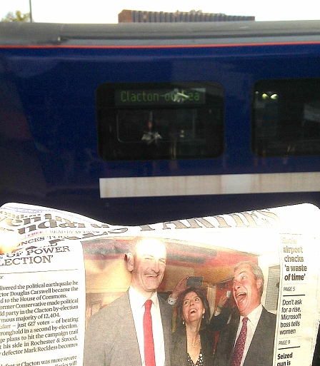 © Robert Rotifer Zeitung mit Carswell und Farage drauf vor Zug, der nach Clacton-on-Sea geht.
